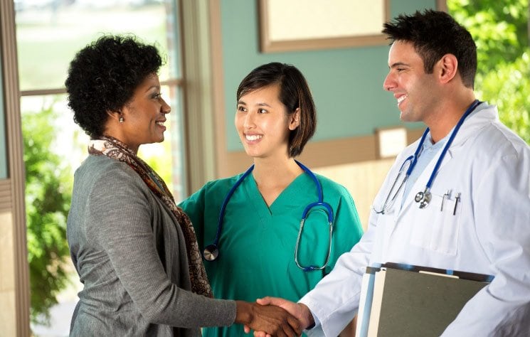 Group of three diverse doctors taking turns shaking hands